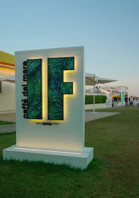 L'insegna illuminata del Caffè del Mare IF Roma al tramonto