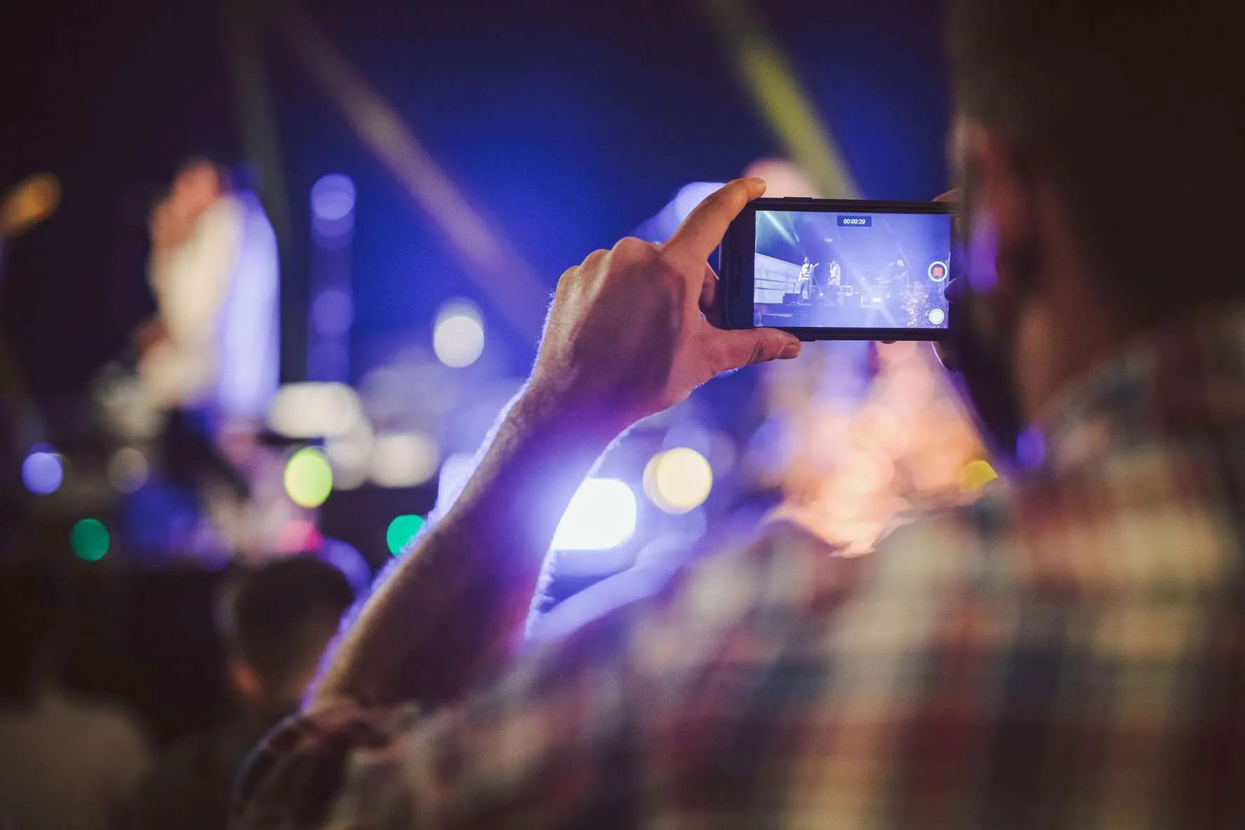 Spettatore che riprende il concerto con lo smartphone alla Terrazza Gianicolo