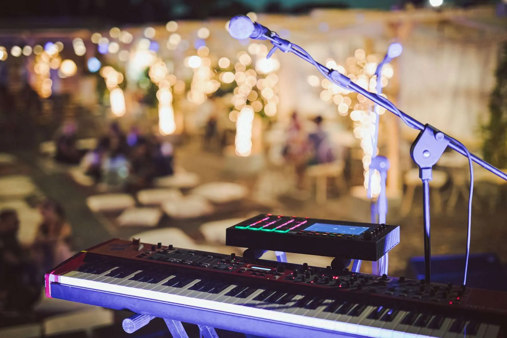 Tastiera e microfono sul palco della Terrazza Gianicolo, luci sullo sfondo