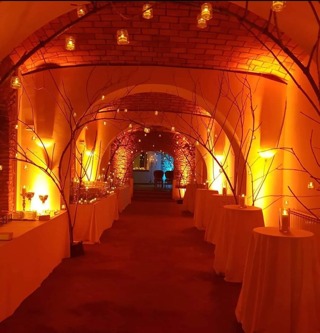 Corridoio interno con volte a mattoni illuminato da candele